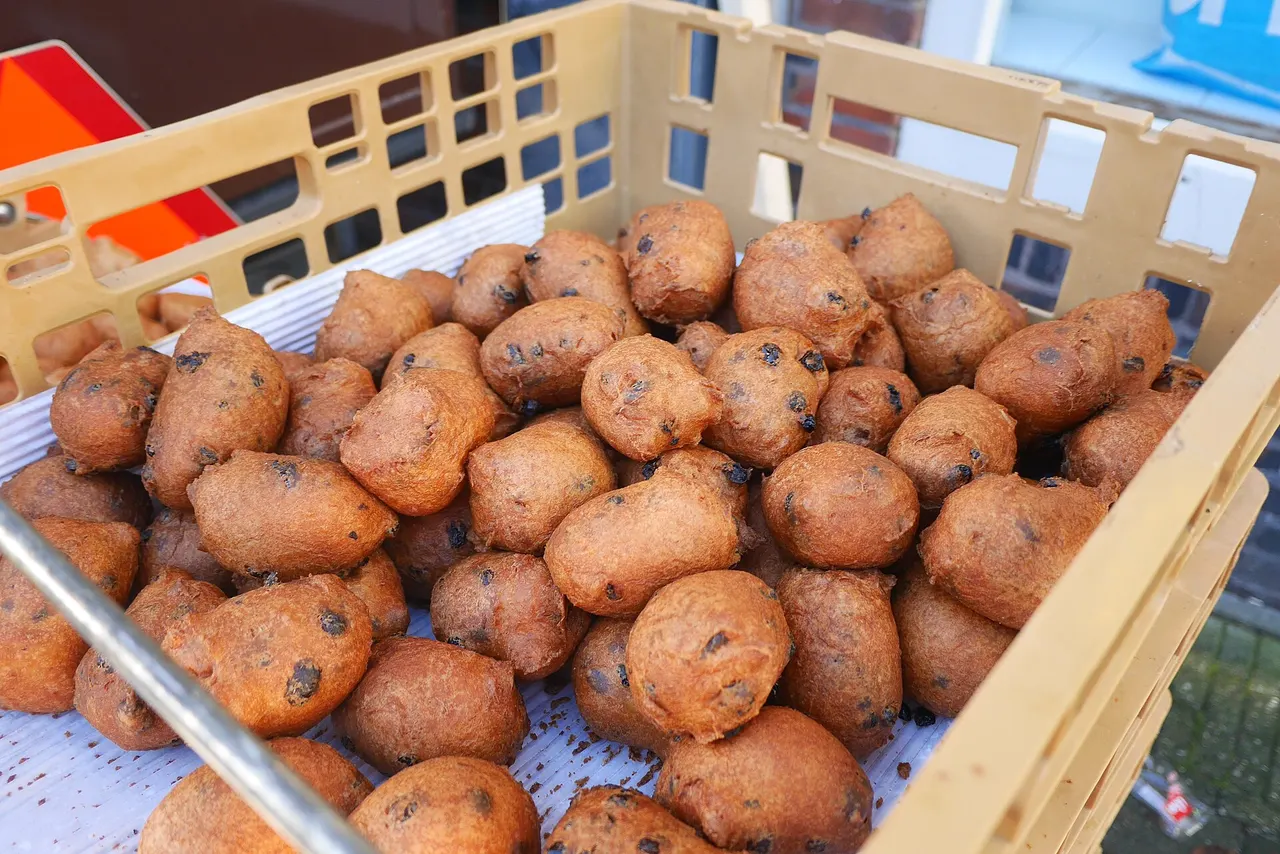 Vers gebakken oliebollen met krenten in een bak op de markt